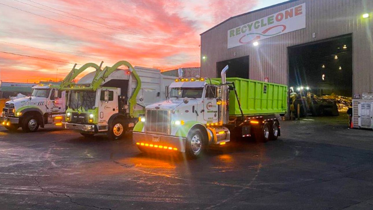 truck pulling out of garage at dusk under a sign that says recycle one.