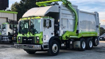 green and white garbage truck.