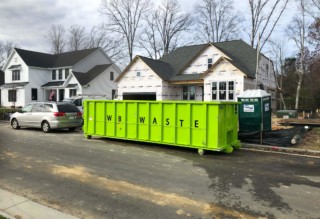residential roll of dumpster in front of house under construction.